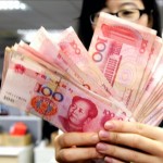 Una trabajadora de una oficina postal con varios billetes de yuanes, en Pekín (China). EFE/Archivo