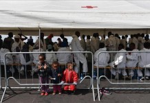 Un grupo de inmigrantes descansa bajo una carpa de la Cruz Roja después de desembarcar en Italia. EFE/Archivo