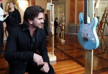 El cantante colombiano Juanes observa la guitarra intervenida por el músico Carlos Vives en Bogotá (Colombia).