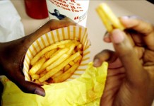 Una mujer sin identificar come patatas fritas en un restaurante. Archivo